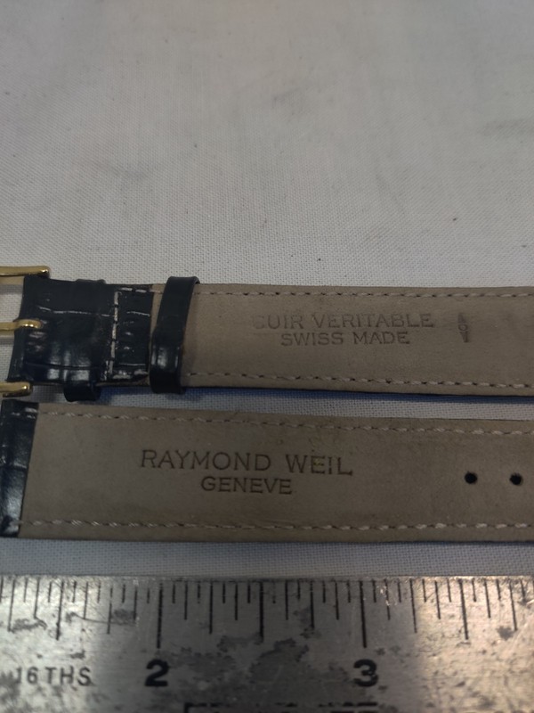 Raymond Weil watch strap is made of black leather and features a gold buckle.